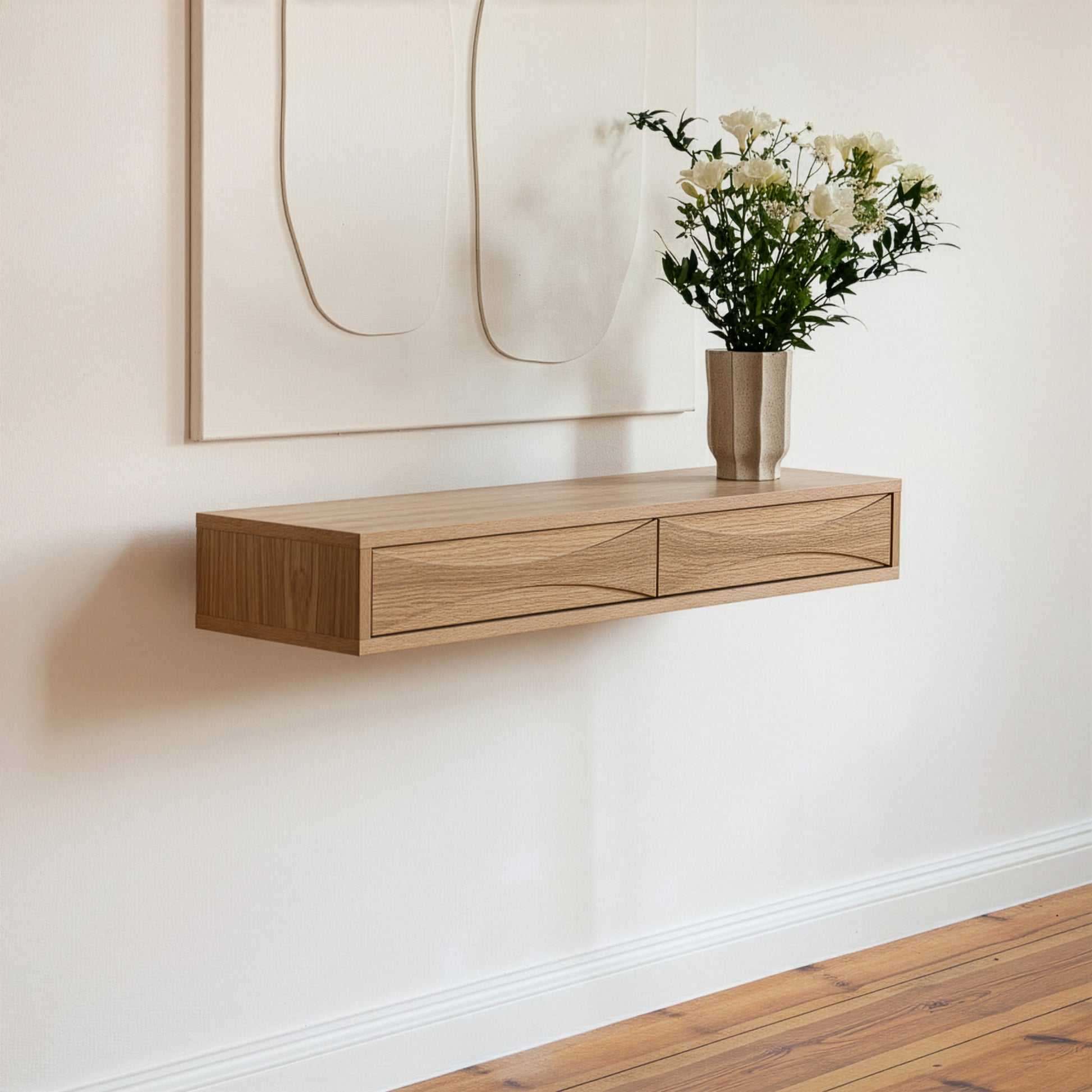 Wooden wall-mounted console table with a vase of flowers against a white wall.